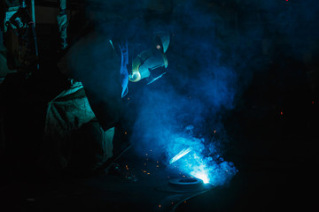 Obraz na płótnie Canvas Welder of Metal Welding with sparks and smoke in steel industry