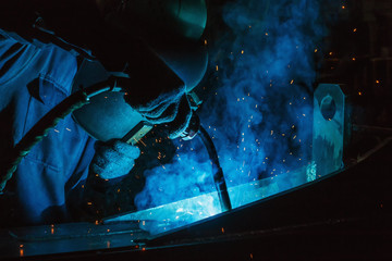 Welder of Metal Welding with sparks in industry steel weld