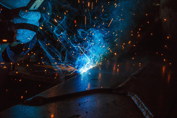 Welder of Metal Welding with sparks in industry steel weld