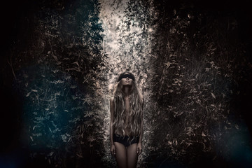 Fototapeta premium Young beautiful blindfolded woman in forest. Alone in the dark 