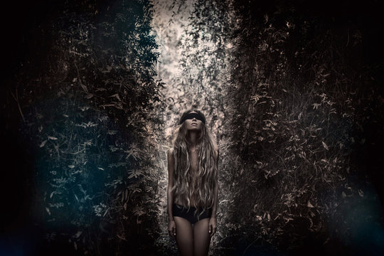 Fototapeta Young beautiful blindfolded woman in forest. Alone in the dark 