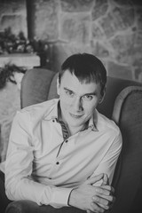 Fototapeta premium young man sitting on background of Christmas interior