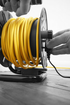 Abstract image of a man connecting plug to an extension lead