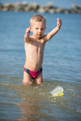 Little boy with snorkel by the sea. Cute little kid wearing mask and flippers for diving at sand tropical beach. Ocean coast.