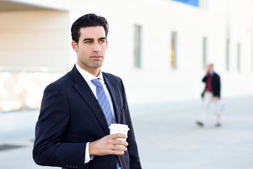 Businessman drinking coffee to go with a take away cup