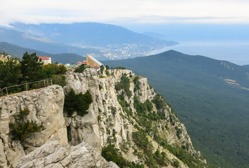 Fototapeta na wymiar mountain, houses on the rock, at the bottom of the cliffs the sea, forest