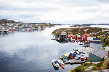 Fototapeta na wymiar Scandinavian village in miniature. Panorama of the town. Small houses, boats. Coast Sea. Tilt shift effect. Europe.