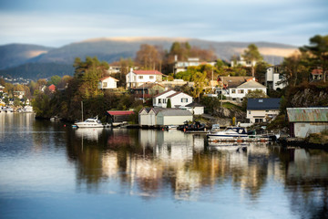 Fototapeta na wymiar Scandinavian village in miniature. Panorama of the town. Small houses, boats. Coast Sea. Tilt shift effect. Europe.