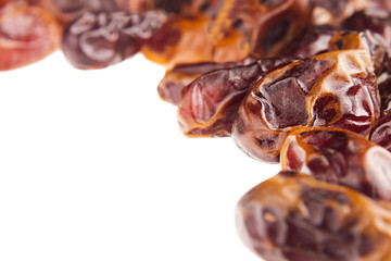 Date fruit  closeup on white background. Isolated. Decorative border of shiny date fruit. Dried fruit for vegetarian.