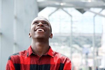 Young african man looking up and smiling