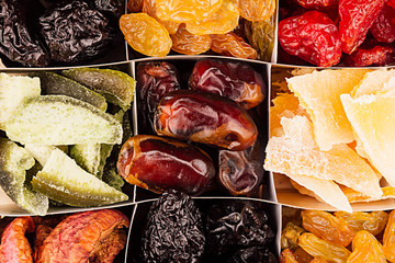 Assortment of dried fruits closeup background in square cells. Decorative pattern of dry exotic fruit. Top view.