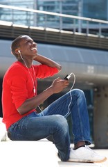 Young african man enjoying listening music on mobile phone