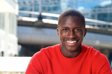 Fototapeta premium Young african man sitting outdoors and smiling