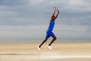 Fit young african man jogging at beach