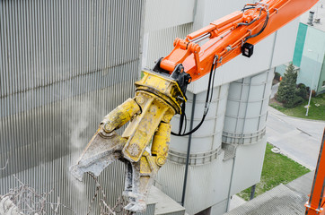 Excavator working at the demolition of an old industrial buildin