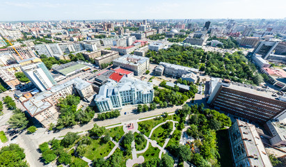 Aerial city view with crossroads, roads, houses, buildings, parks and parking lots. Copter drone helicopter shot. Panoramic wide angle image.