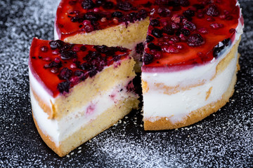 Homemade berry cream cake on black background