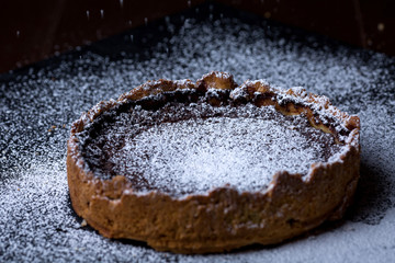 Homemade chocolate tart on black background