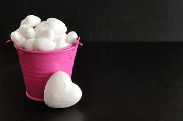 Valentine's Day. White polystyrene hearts in a pink bucket