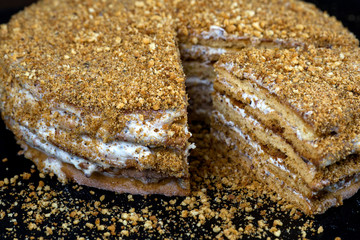 Homemade honey cake with cut piece  on black background