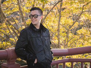 a man relaxing with a beautiful Japan , Nikko autumn tree . focus on the model . Japan autumn set
