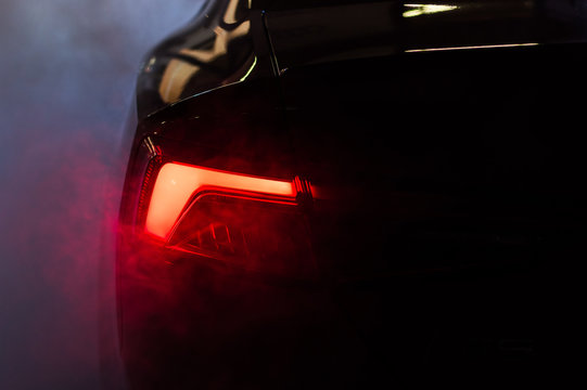 Car red taillights with smoke fog around it