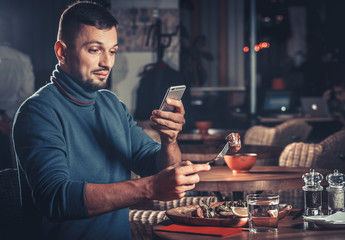 Handsome man photographing food at the restaurant