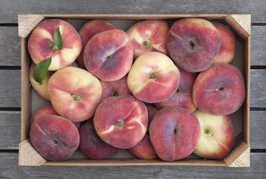Wooden box of fresh Saturn peaches