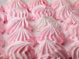 white meringue cookie among pink meringues, shallow depth of field, selective focus