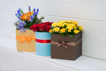 Bouquet with orange daisies, yellow and red roses in gift box