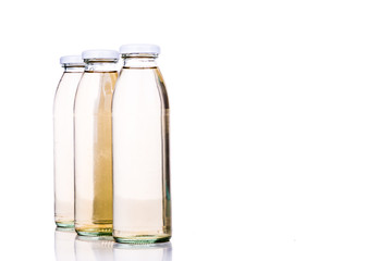 Translucent liquid in glass bottle on white background
