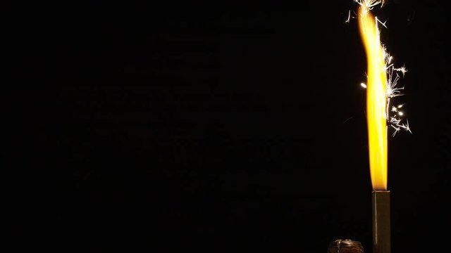 4K Tilt down of flaming fountain firework attached to a  new bottle of champagne, in slow motion - with space for text