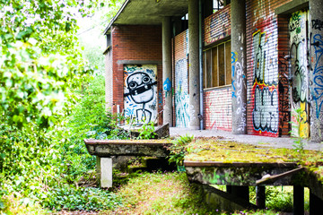 Abandoned campus restaurant being eaten by nature and grafitti