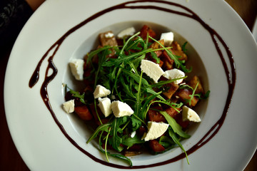 Restaurant food with fresh ingredients - vegetable salad with goat cheese and fresh rucola