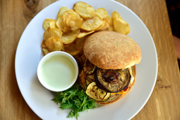Restaurant food with fresh ingredients - hamburger with cheddar cheese, zucchini, potato slices and tartar sauce