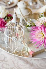 Shabby chic decoration with beautiful vintage birdcage and flowers . Wedding decor idea