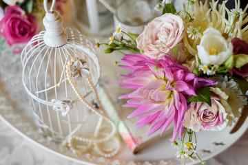 Shabby chic decoration with beautiful vintage birdcage and flowers . Wedding decor idea