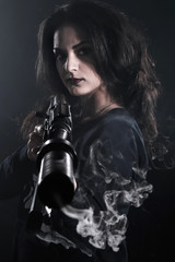 Obraz na płótnie Canvas Young woman holding an assault rifle