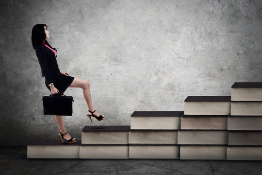 Businesswoman walking on the books stair