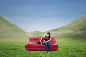 Naklejka premium Asian mother and son play touchpad outdoor