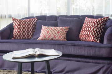 Magazine on table with violet sofa set in background