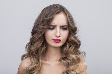 Fototapeta premium Doubtful woman with long vawy hair