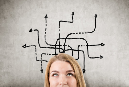 Girl's Head And Tangled Arrows On A Concrete Wall