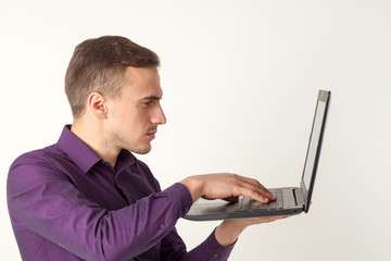 Businessman typing on a laptop. Side view and front. He is very busy and inspired. He is successful and angry.