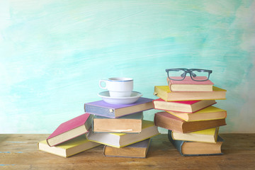 stack of old books with spectacles and cup of coffee, grungy bac