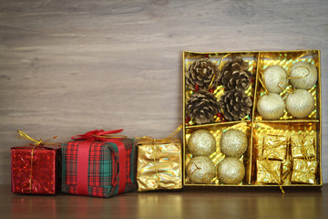 decorations and gift boxes on wooden board with Christmas backgr
