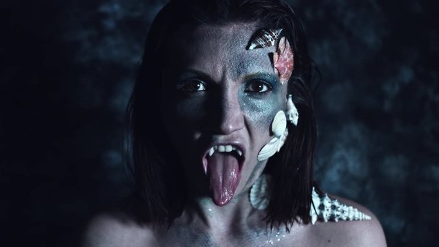 4k Halloween Shot of a Horror Woman Mermaid Showing long Tongue and Fangs