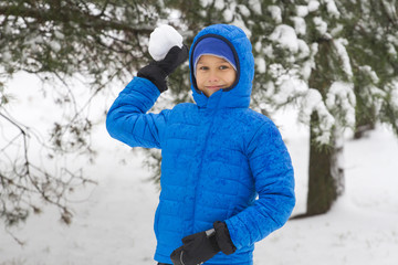 Fototapeta na wymiar Boy throw snowball. Wintertime fun