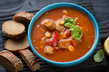 Blue bowl with tilapia chowder and sliced baguette, close-up