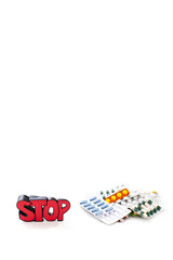Colorful drugs and pills with sign STOP